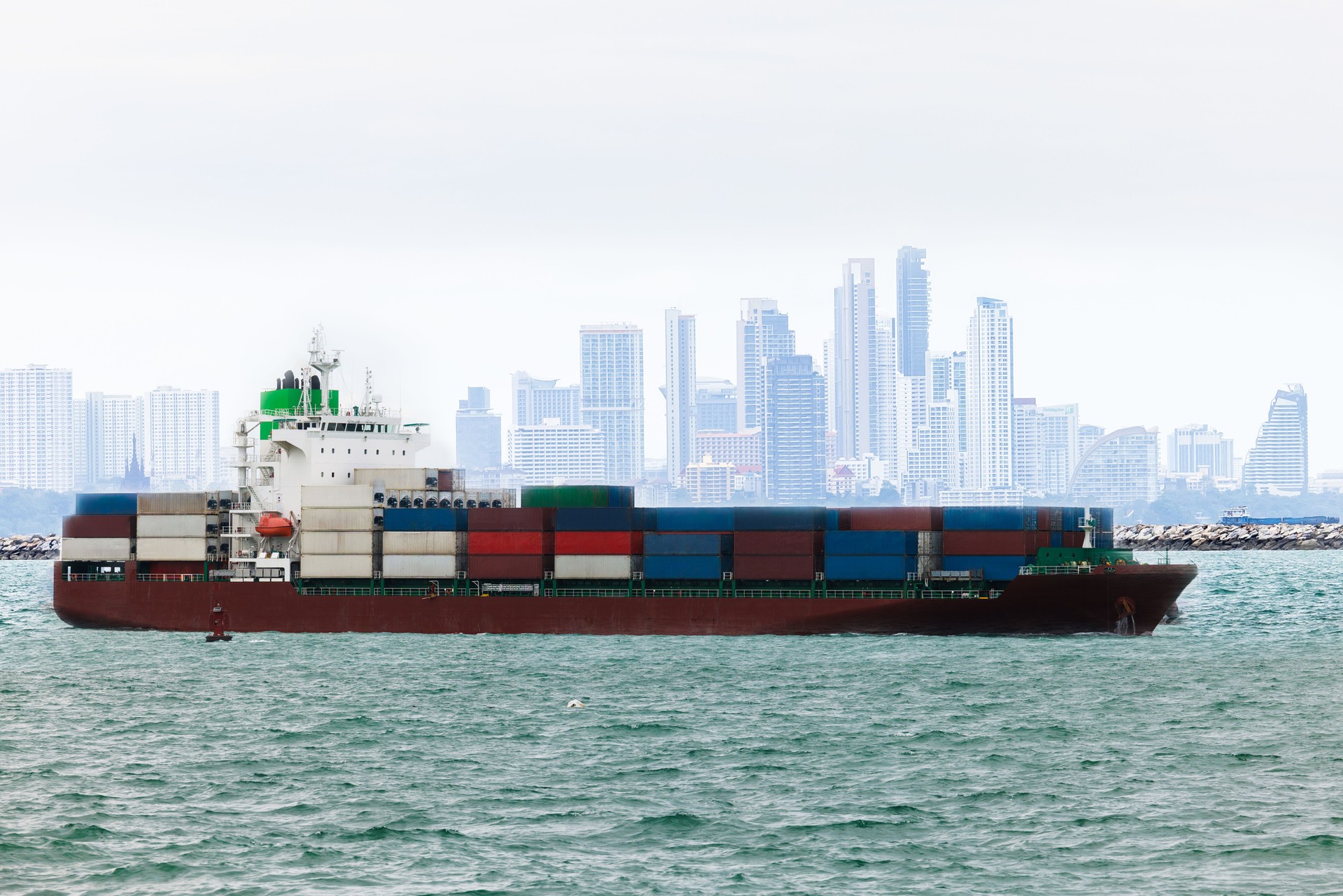 shipping logistic cargo container ship in sea import export goods and distributing products to dealer and consumers across worldwide, by container ship transport business, industry delivery service.  aerial view.